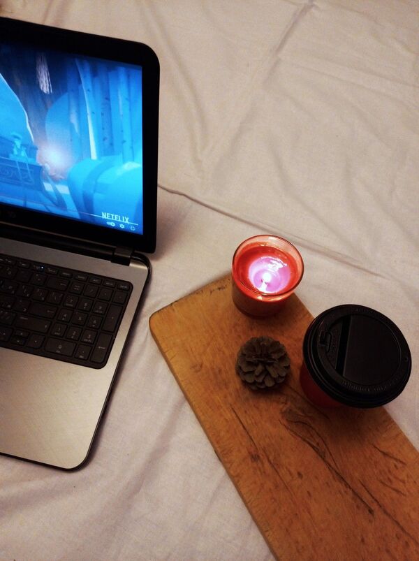 Notebook, candle, and cup on a small table